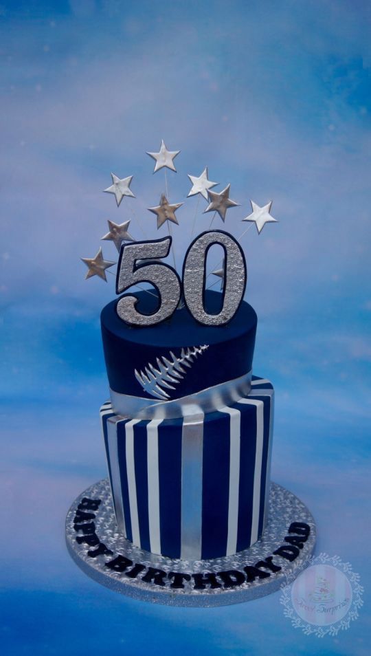 a blue and white cake with silver stars on the top that reads 50 years old