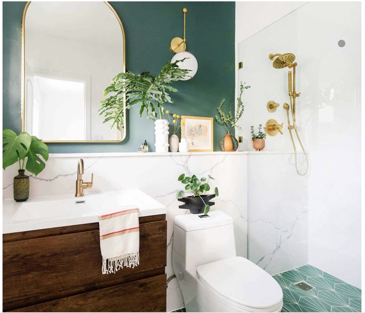 a white toilet sitting next to a bathroom sink under a mirror above a wooden cabinet