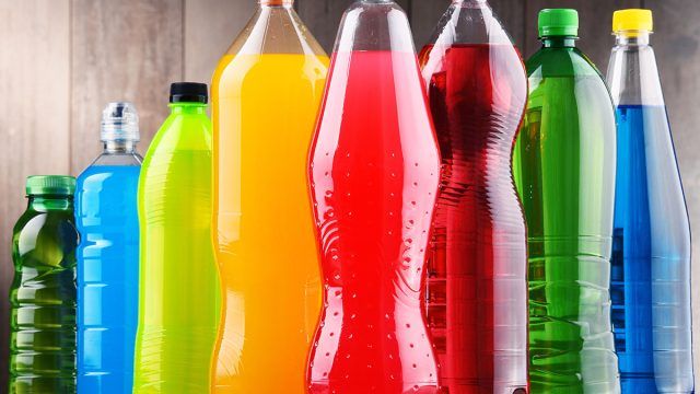 many different colored bottles are lined up in a row