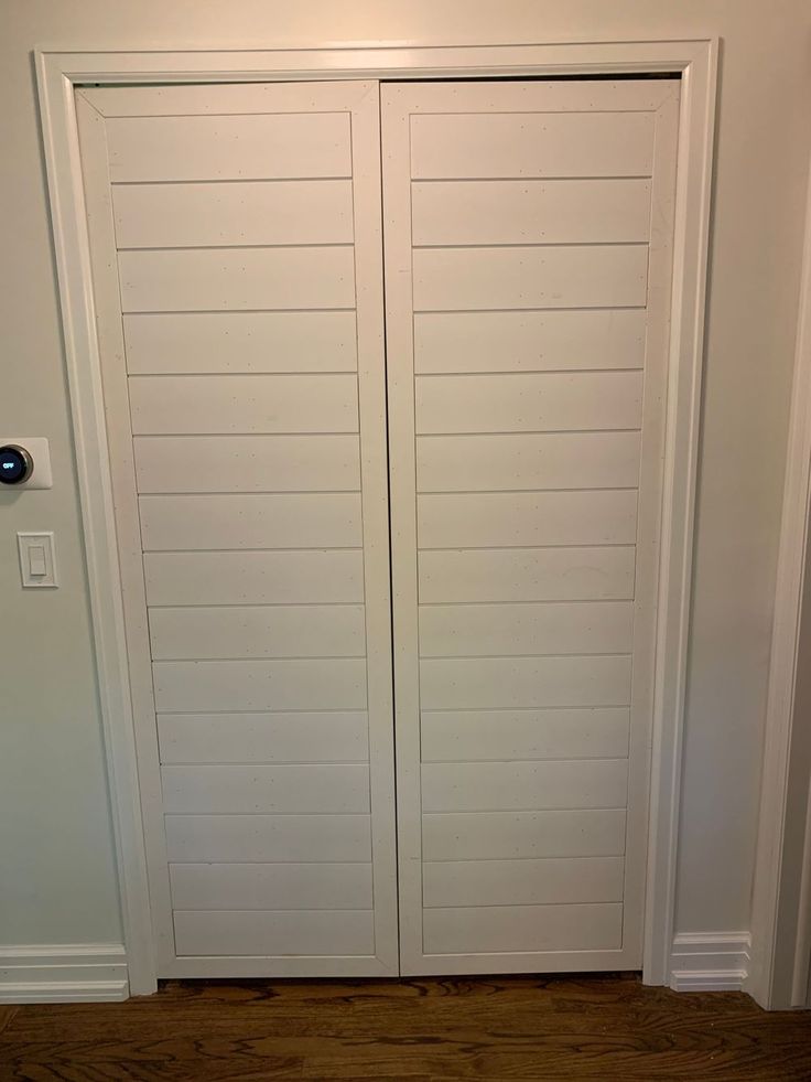 two white doors are open in a room