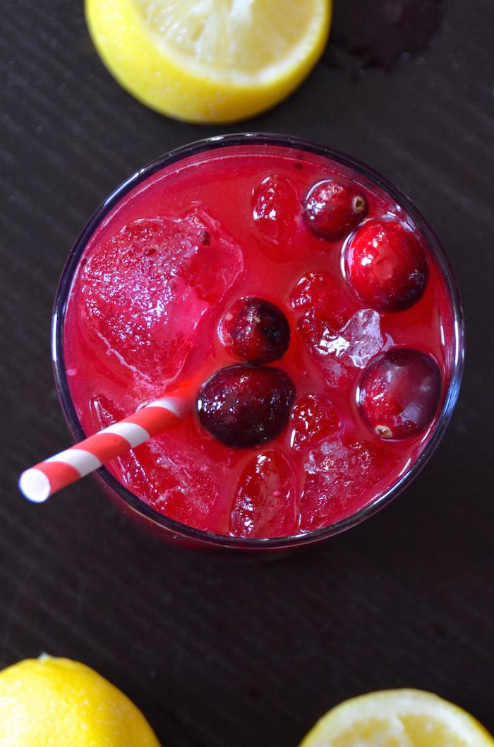 a red drink with cherries and lemons on the side