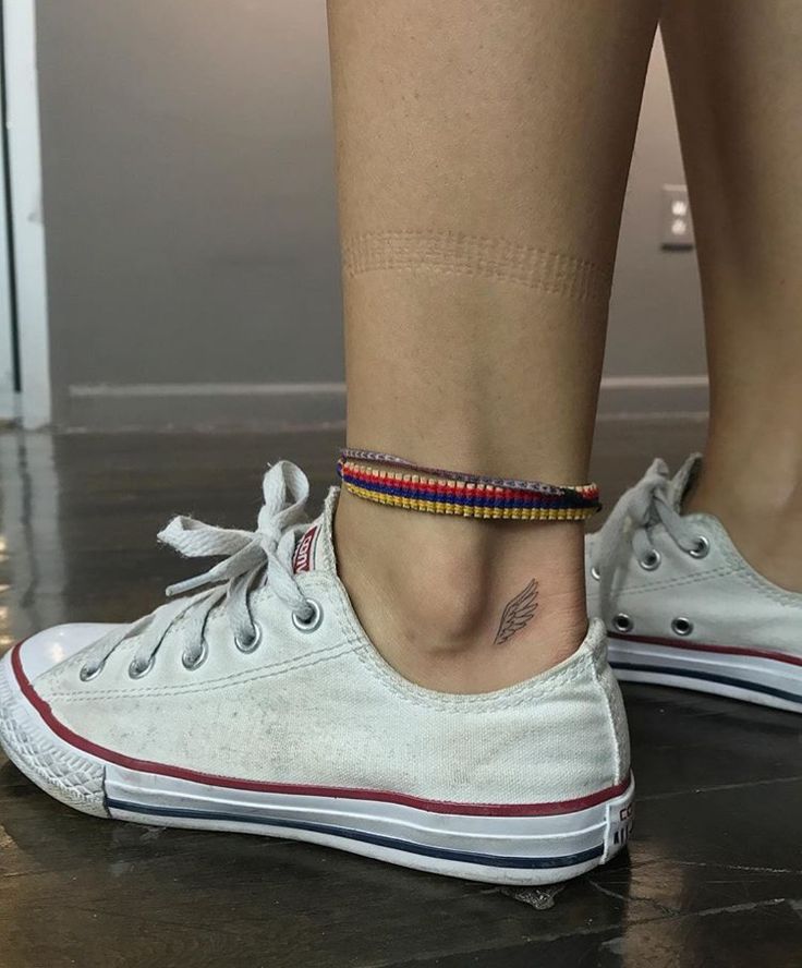 a close up of a person's foot with a tattoo on their left ankle