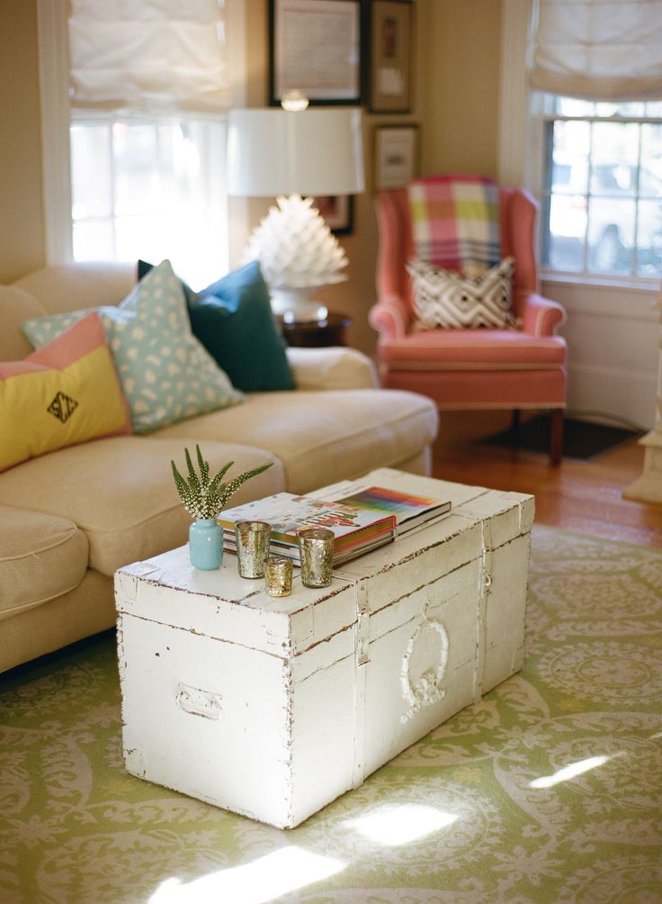 a living room filled with furniture and a white table topped with a potted plant