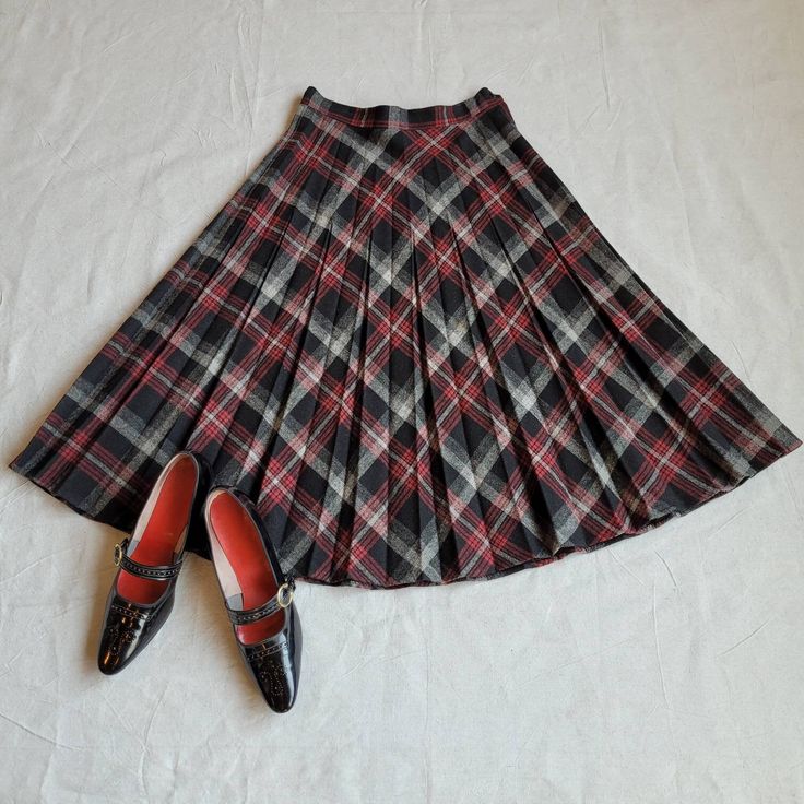 "Brand: unknown  Size: 26\" waist; see measurements  Color: black/red Fabric Content: wool   Features: Cut on the bias this skirt sports a smart black and red plaid with alternating pleating. This shape of this piece is done in an A-line so it is great for most body types. The closure is your traditional zipper/button combo on the left side.    Measurements: Waist: 26in  Hip: 34in  Center Back Length: 28in    Condition: Very good    Care: Dry clean only  Vintage sizing varies. Please check your Classic Plaid Skirt For Fall, Fall Fitted Full Pleated Skirt, Fitted Accordion Pleats Skirt For Fall, Fitted Full Pleated Skirt For Fall, Fitted Full Skirt In Plaid, Fitted Accordion Pleat Skirt For Winter, Scottish Red Skirt For Fall, Red Fitted Pleated Skirt For Fall, Fitted Red Pleated Skirt For Fall