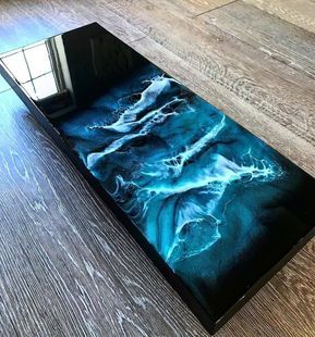 a table that has some kind of blue and white design on it, sitting on top of a wooden floor