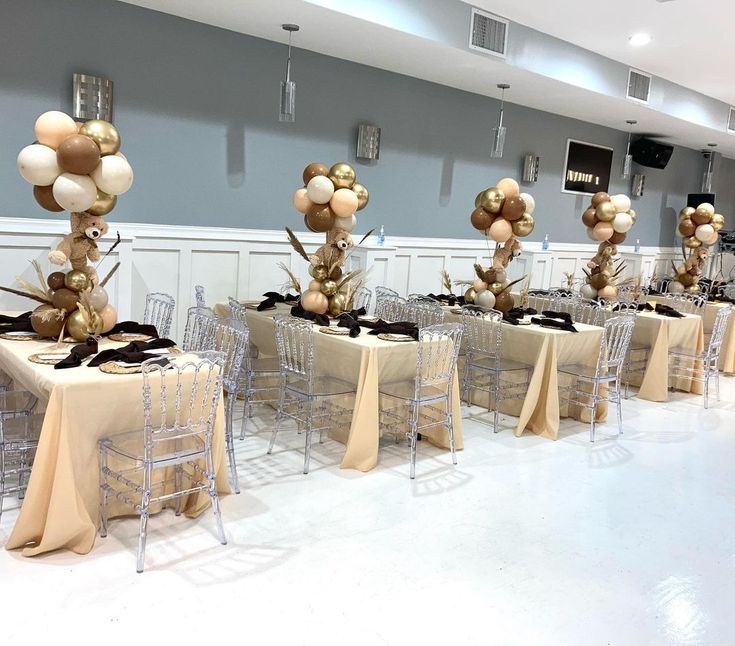 there are many chairs and tables set up for a party with balloons on the table