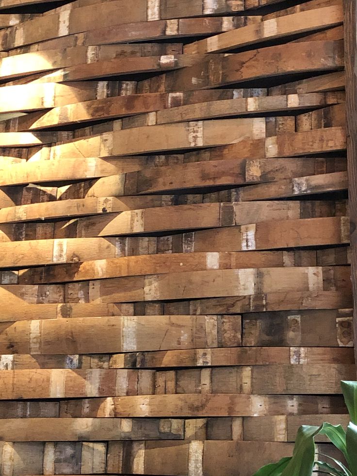 a large stack of wooden pallets sitting next to a plant