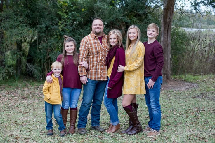 a family poses for a photo in front of some trees