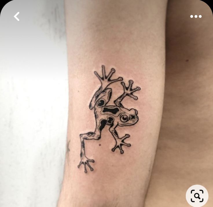 a small frog tattoo on the arm