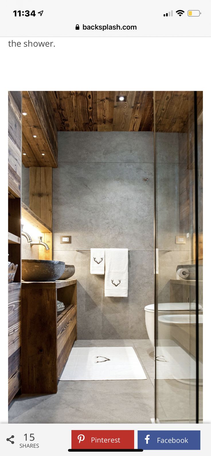 an image of a bathroom with wood and tile on the walls, shower stall, sink, and toilet