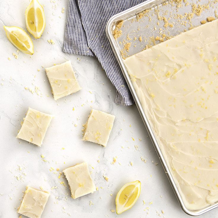 a pan filled with cake batter next to lemons on top of a white counter