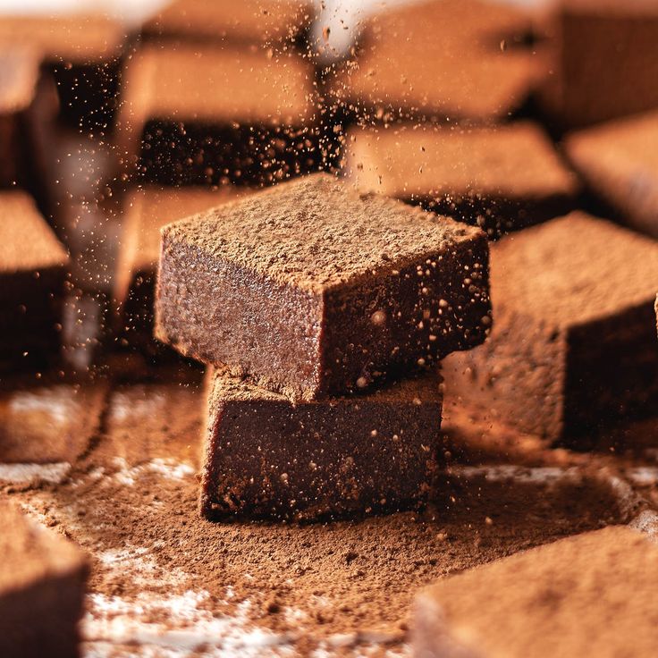 some brownies are stacked on top of each other and sprinkled with powder