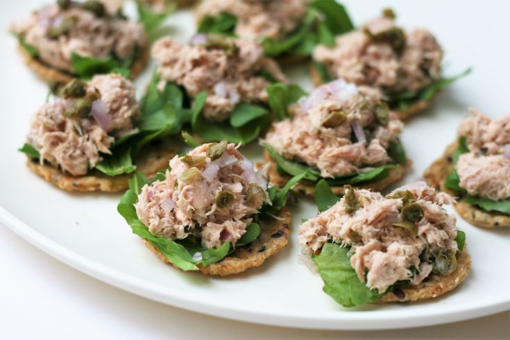 small appetizers are arranged on a plate with lettuce and other toppings