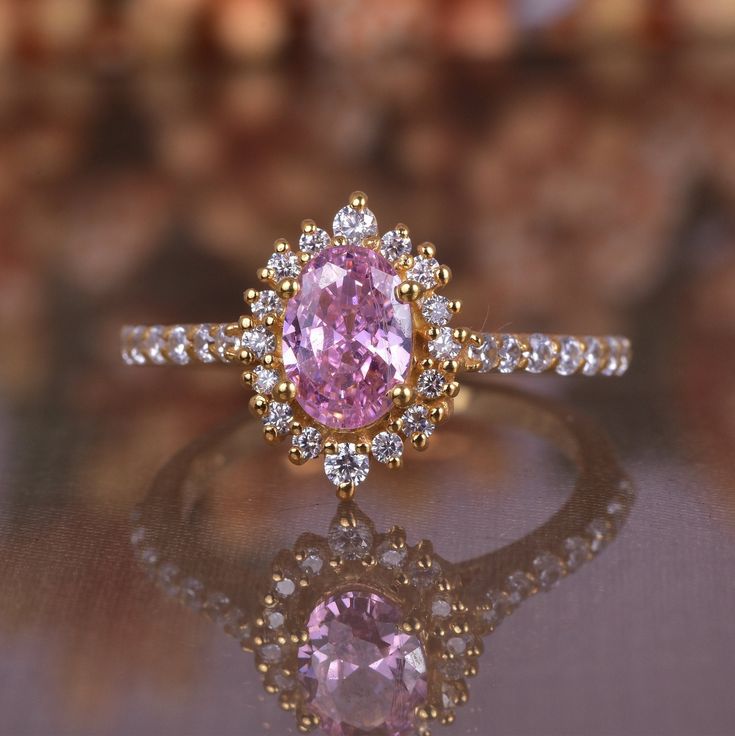 a pink diamond ring sitting on top of a table