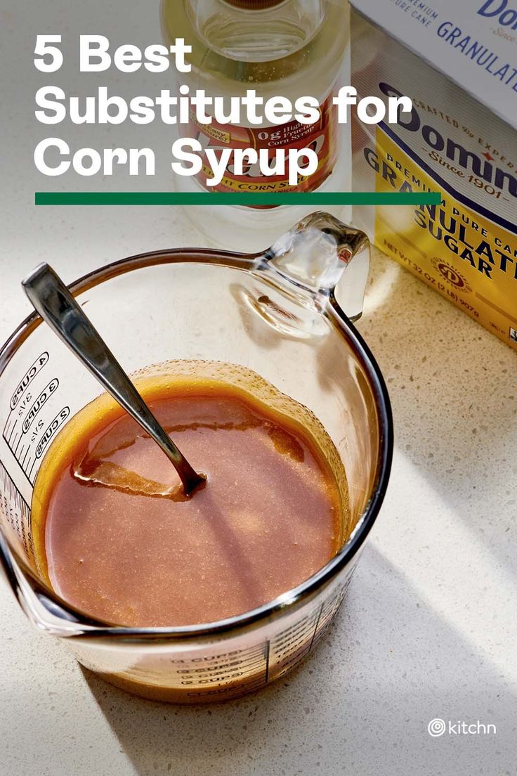 a glass bowl filled with corn syrup next to a bottle of milk and a spoon