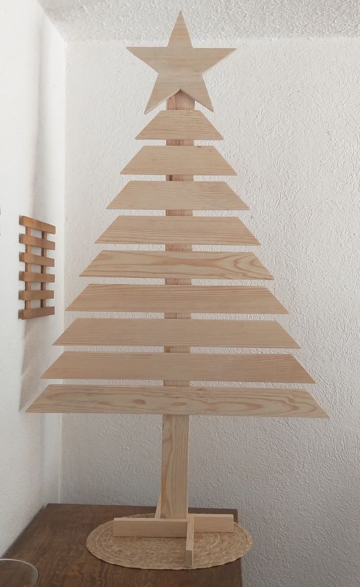 a wooden christmas tree sitting on top of a table