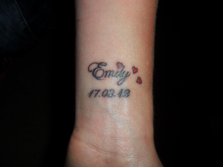 a small wrist tattoo with the words family and hearts