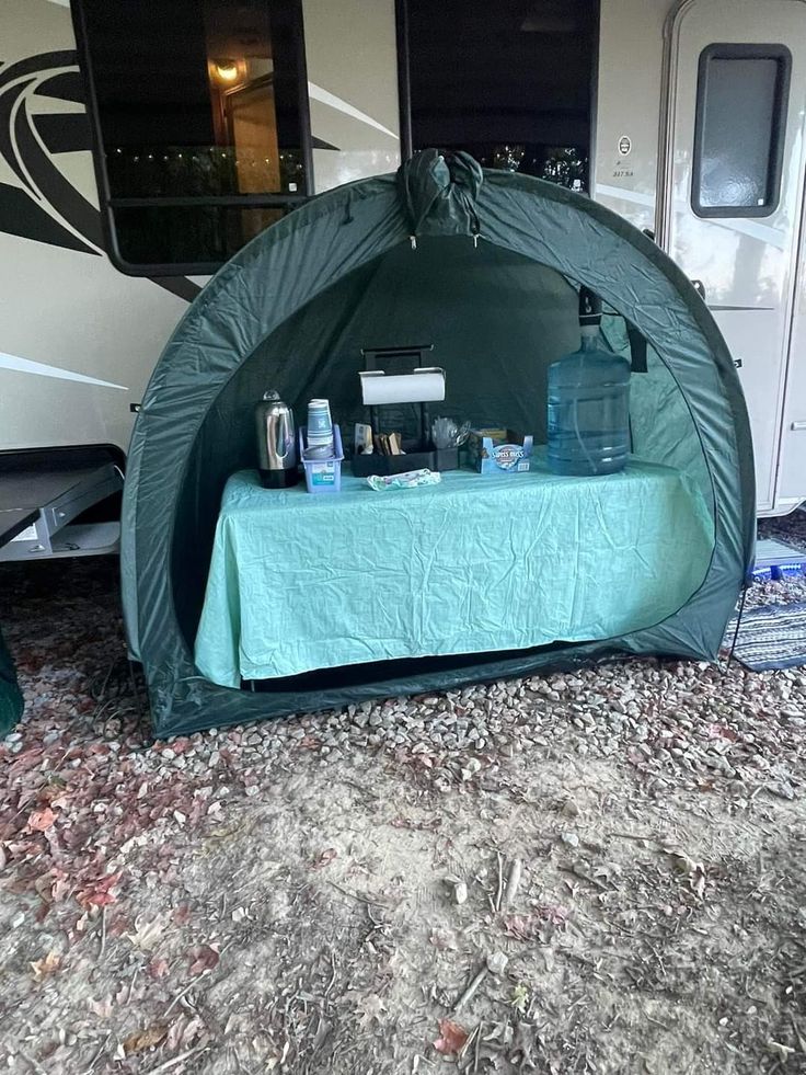 the table is set up in front of the camper's tent with its door open