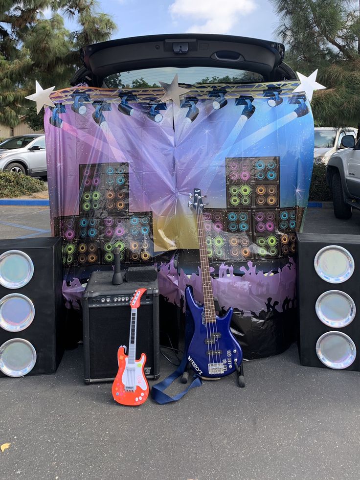 guitars and amps are sitting in front of a car