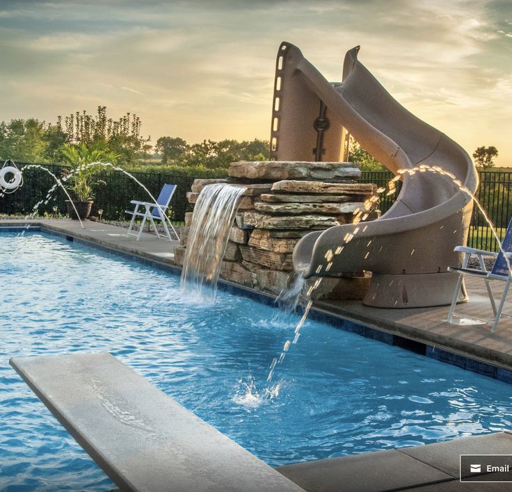 an outdoor pool with a slide and water features