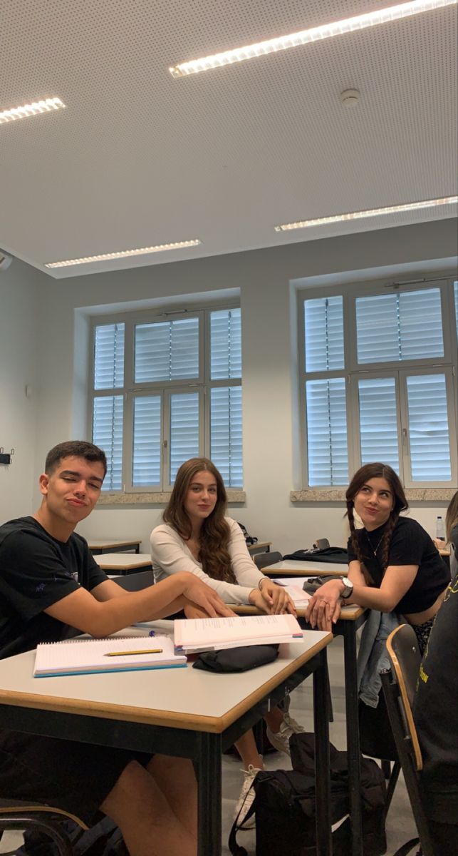 four students sitting at desks in a classroom