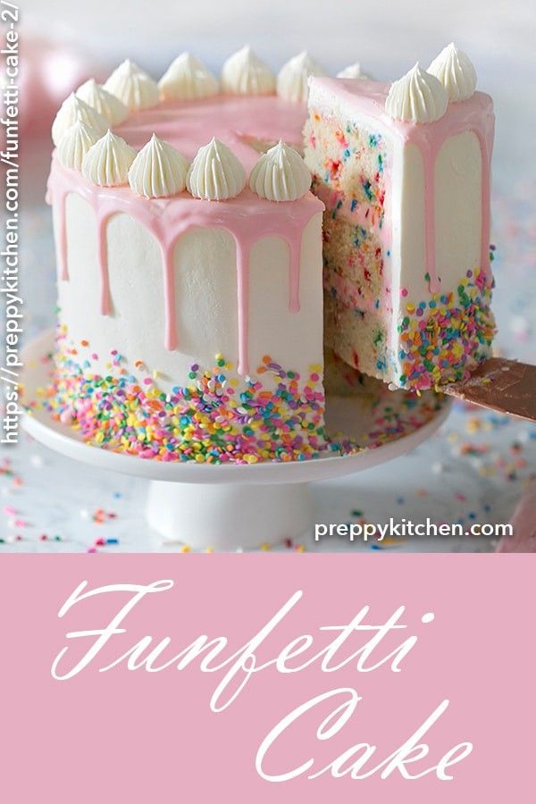 a pink cake with white frosting and sprinkles