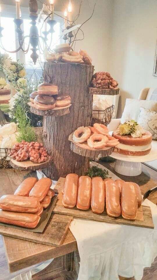 a table topped with lots of food covered in donuts and other foods on top of wooden trays