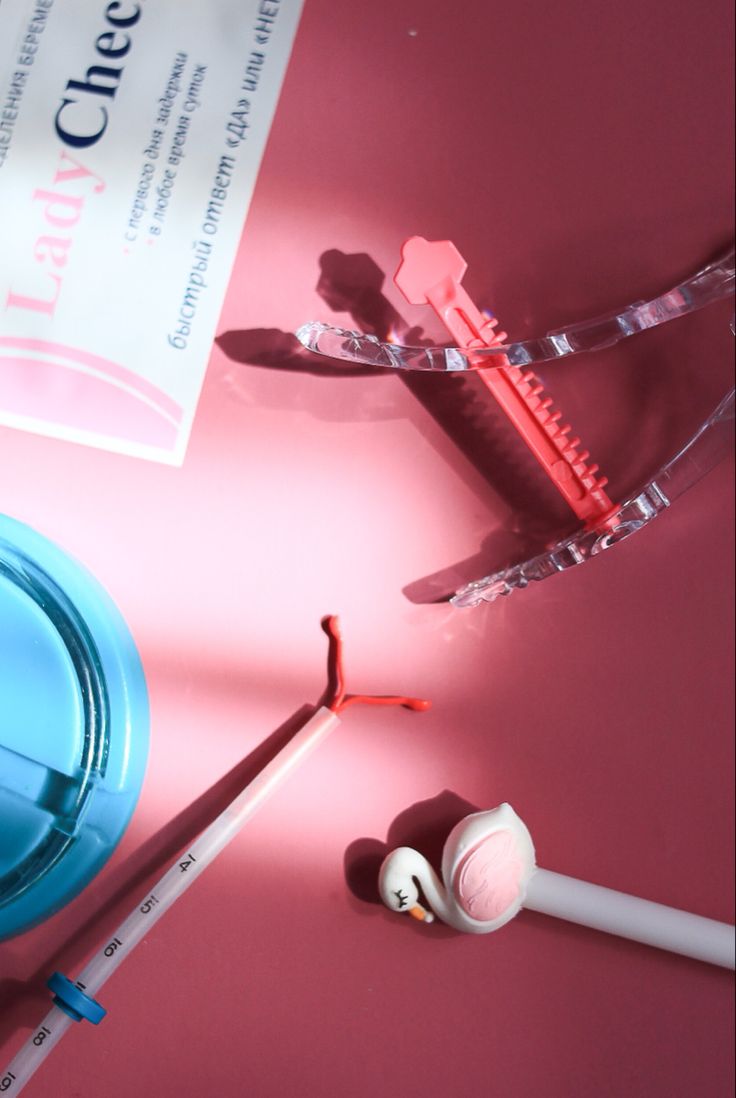 an assortment of medical supplies on a pink surface