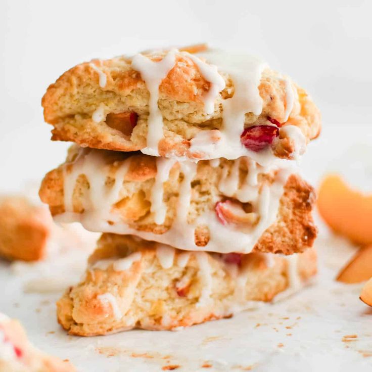 three cranberry orange scones stacked on top of each other with icing