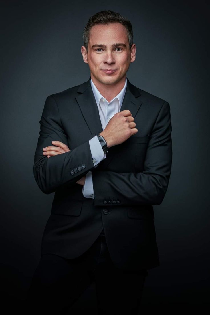 a man in a suit and tie with his arms crossed