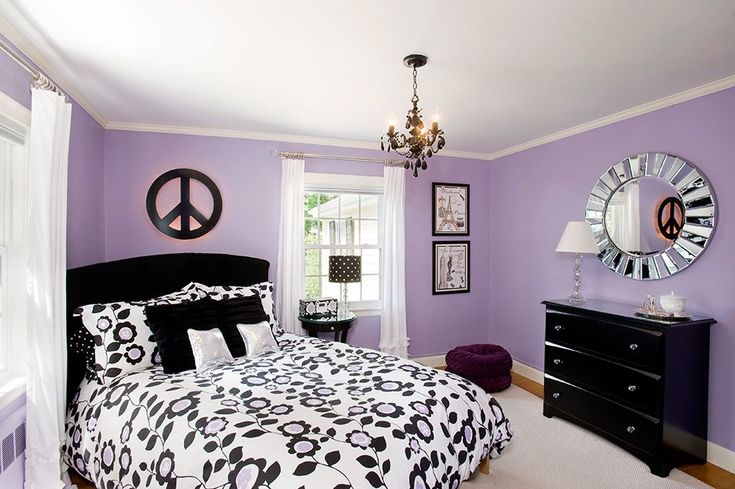 a bedroom decorated in purple and black with peace signs on the wall above the bed