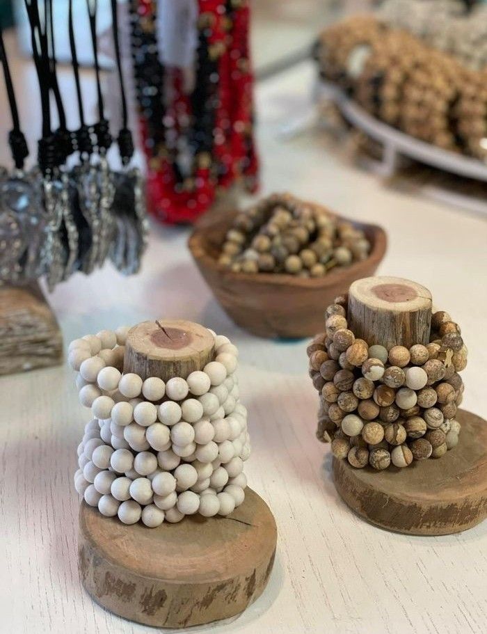 several different types of beaded objects on display in a store or showroom, including beads and wood slices