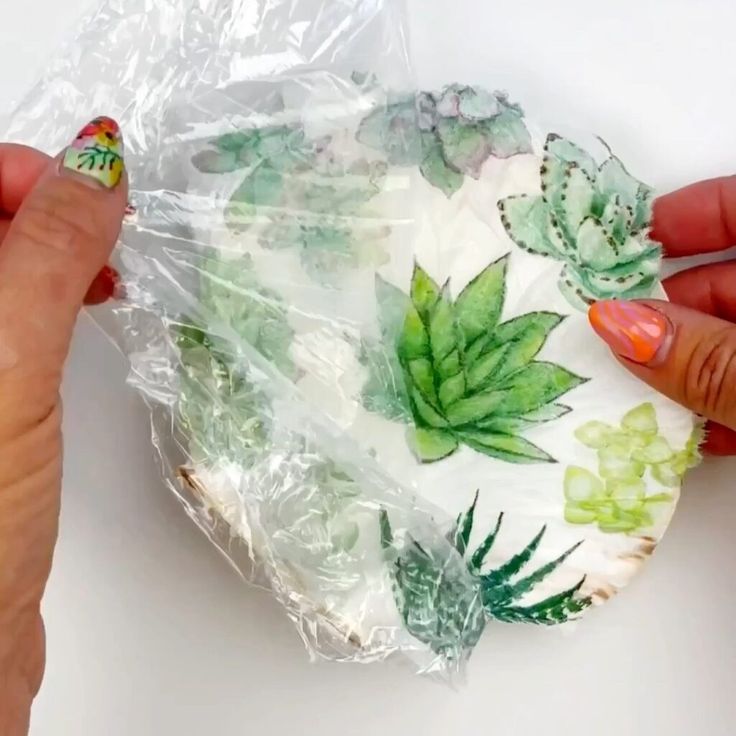 a person holding a plastic bag with green leaves on it and another hand reaching out to grab one