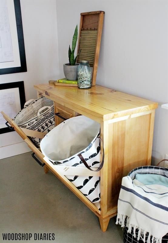 a wooden table with two bowls on it next to a potted plant and a mirror