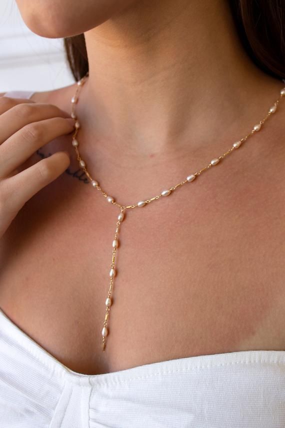 The Dripping Freshwater Pearl Necklace is composed of 4mm freshwater rice pearls separated by 14k gold filled or sterling silver dainty bars.  A 3 1/2" matching drop elegantly flows into mid-air.  Due to the nature of handmade, each one is slightly different and unique to you."Dripping Freshwater Pearl Necklace" by GoldenLinings - Christine Elizabeth JewelryD E T A I L S_________________Materials: 14K Gold Fill or Sterling SilverClosure: lobster claspS I Z E S__________Measures approx. 20" neckl 14k Gold Filled Pearl Drop Teardrop Necklace, Gold Long Drop Pearl Necklace As Gift, Gold Long Drop Necklace With Pearl, Gold Pearl Necklace With Long Drop For Gift, Gold Drop Necklace With Pearl Chain, Dainty Drop Pearl Jewelry, Adjustable Gold Drop Necklace With Pearl, Dainty Long Drop Pearl Necklaces, Dainty Long Drop Pearl Drop Necklace