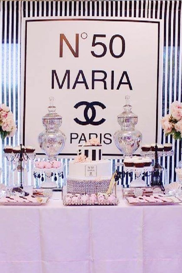 a table topped with cakes and desserts next to a sign that reads n50 maria paris