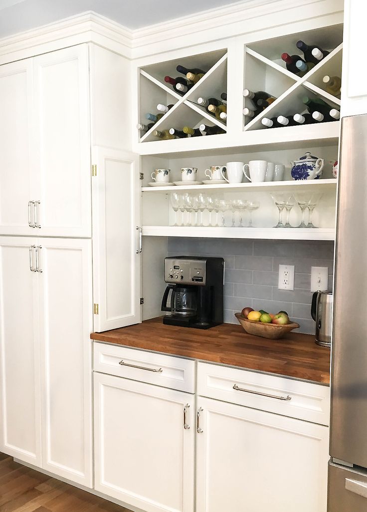 a kitchen with white cabinets and wooden counter tops