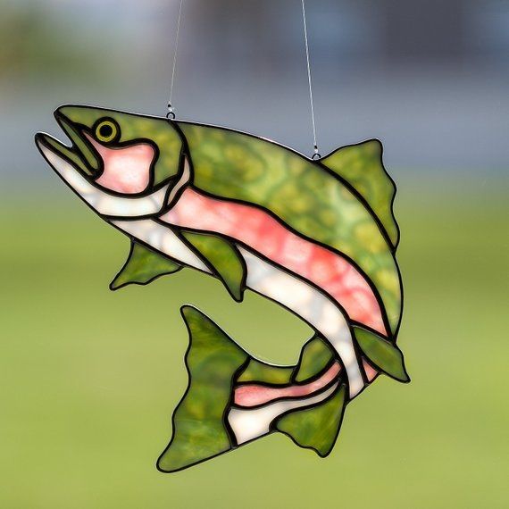 a stained glass fish hanging from a string