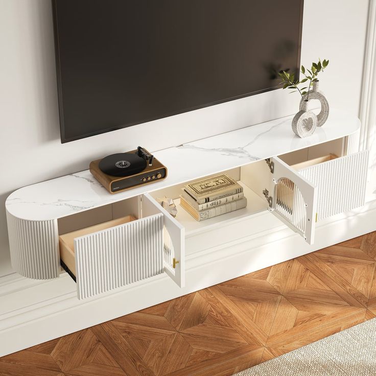 a white entertainment center with books and record player