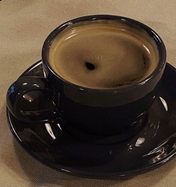 a black coffee cup sitting on top of a saucer