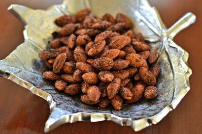 a bowl filled with nuts sitting on top of a wooden table