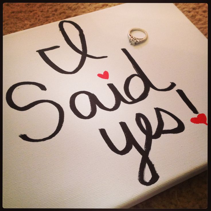 i said yes painted on a canvas with a wedding ring sitting on top of it