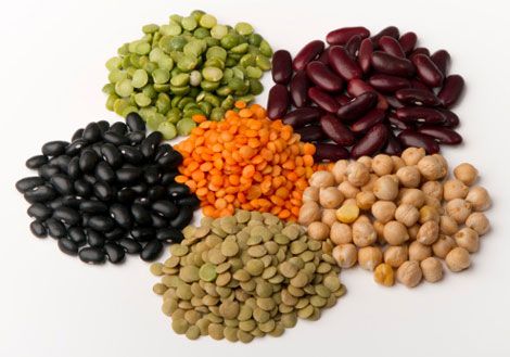 beans, peas, and lentils are arranged on a white surface