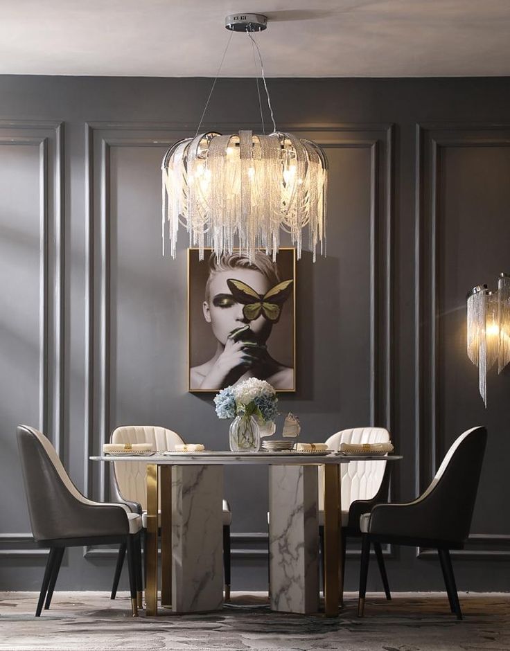 an elegant dining room with grey walls and marble table, chandelier and chairs