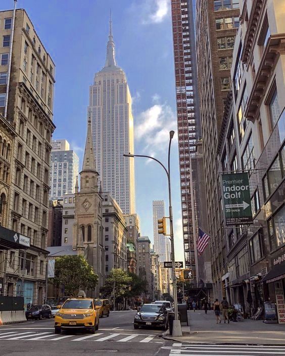 a city street with tall buildings in the background