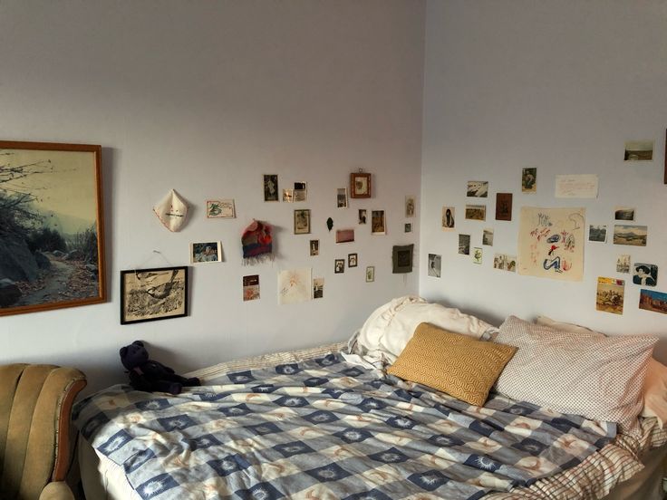 a bed sitting in a bedroom next to a wall with pictures on it