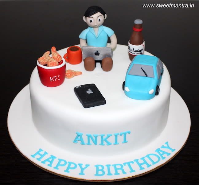 a birthday cake with an image of a man sitting on his lap and holding a laptop