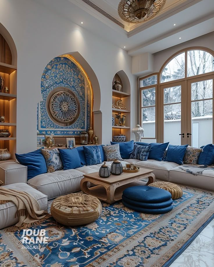 a living room filled with lots of furniture next to large windows and a blue rug