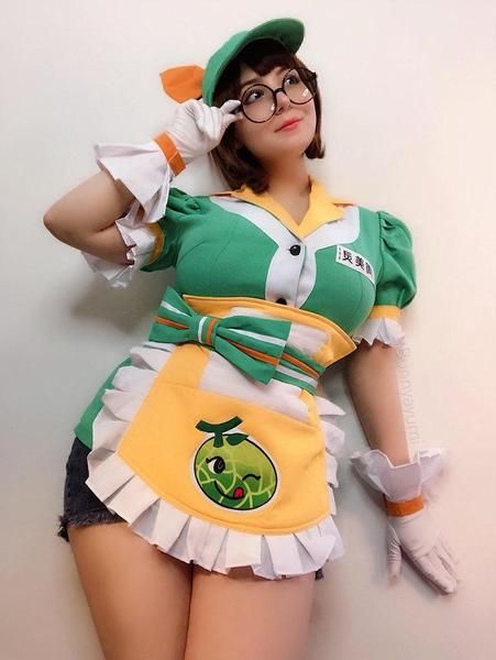 a woman in a green and yellow costume posing for the camera with her hands behind her head