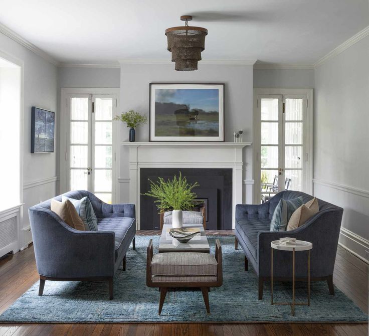 a living room filled with furniture and a fire place under a painting on the wall